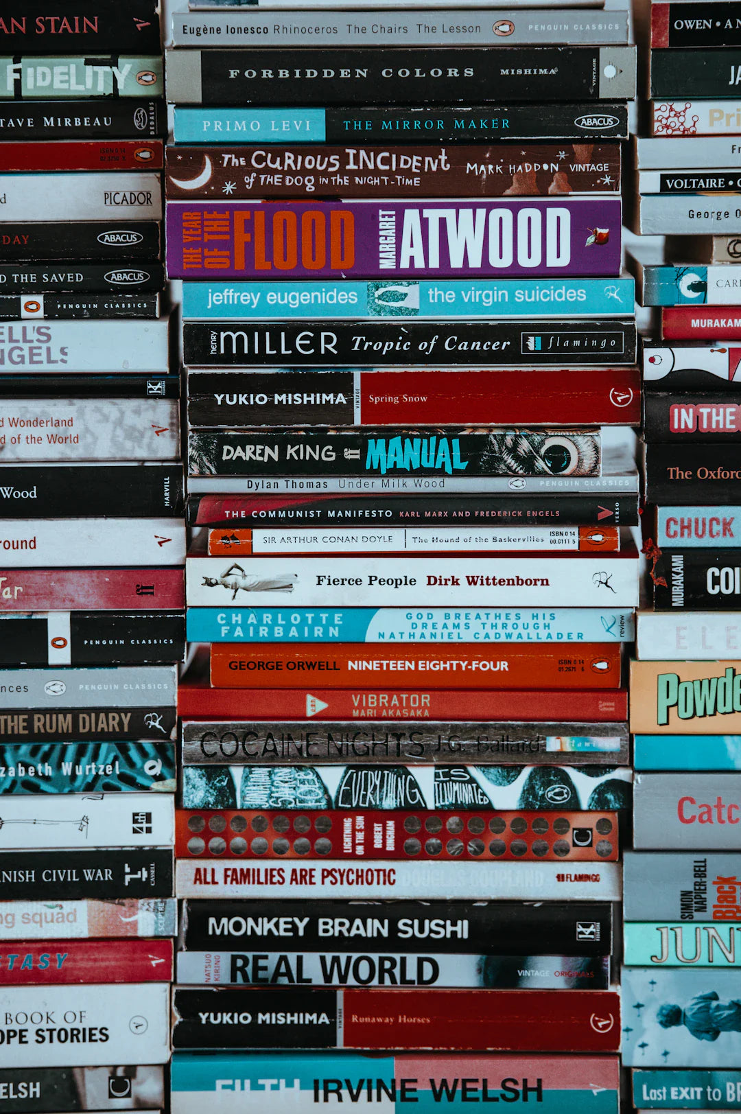 Stack of colorful books representing graphic novels and postmodern literature styles