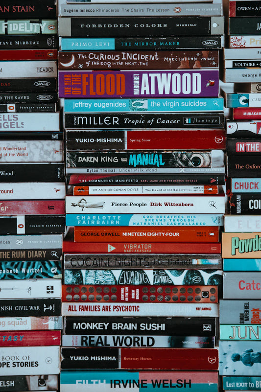 Stack of colorful books representing graphic novels and postmodern literature styles