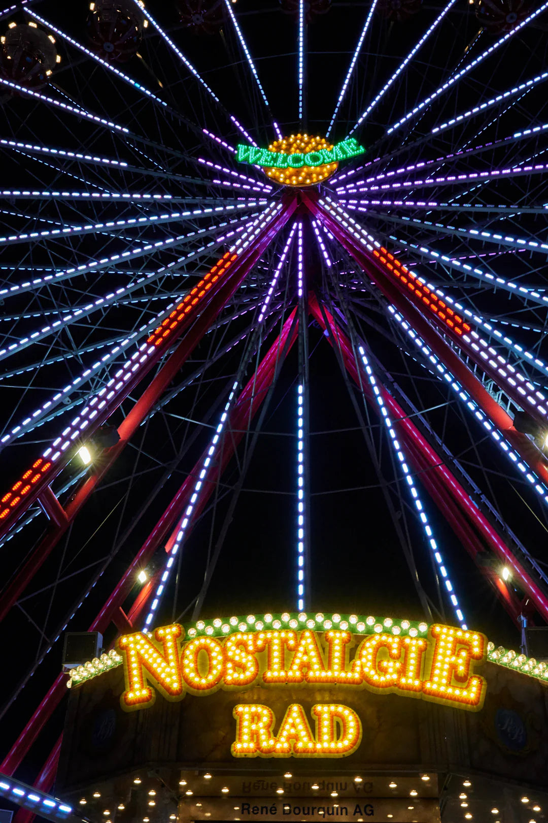 Neon-lit 1960s counterculture ferris wheel with nostalgie rad sign