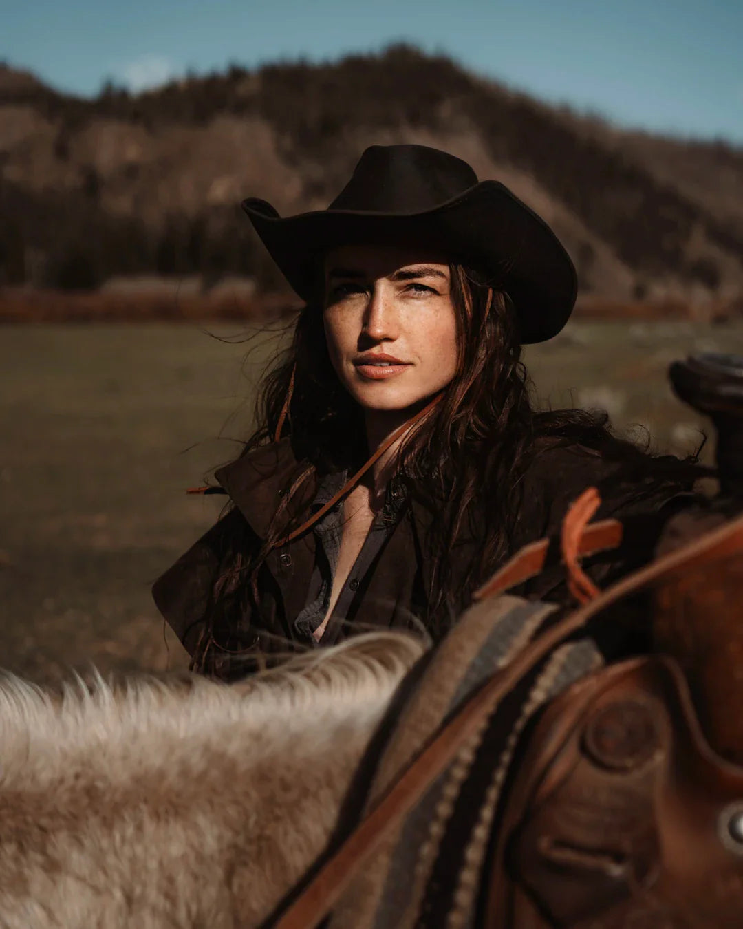 Young woman in cowgirl fashion with cowboy hat and horse, celebrating Western heritage