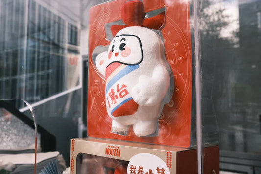 White plush doll with red and blue sash, a nod to iconic vintage mascots like Pillsbury Doughboy