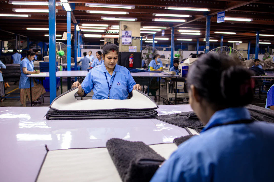 Immigrant worker in blue uniform handling textiles amid factory labor shortages
