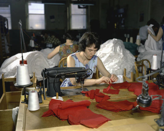 Woman sewing with red fabric highlighting women’s roles and economic empowerment