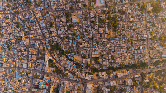 Aerial view of urban sprawl with housing challenges, roads, and green spaces