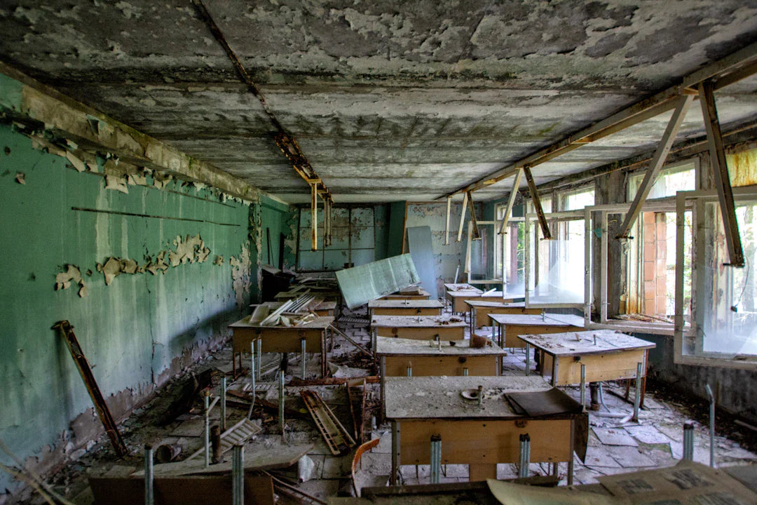 Abandoned classroom with old desks, peeling paint, reflecting the impact of printing press on women’s education