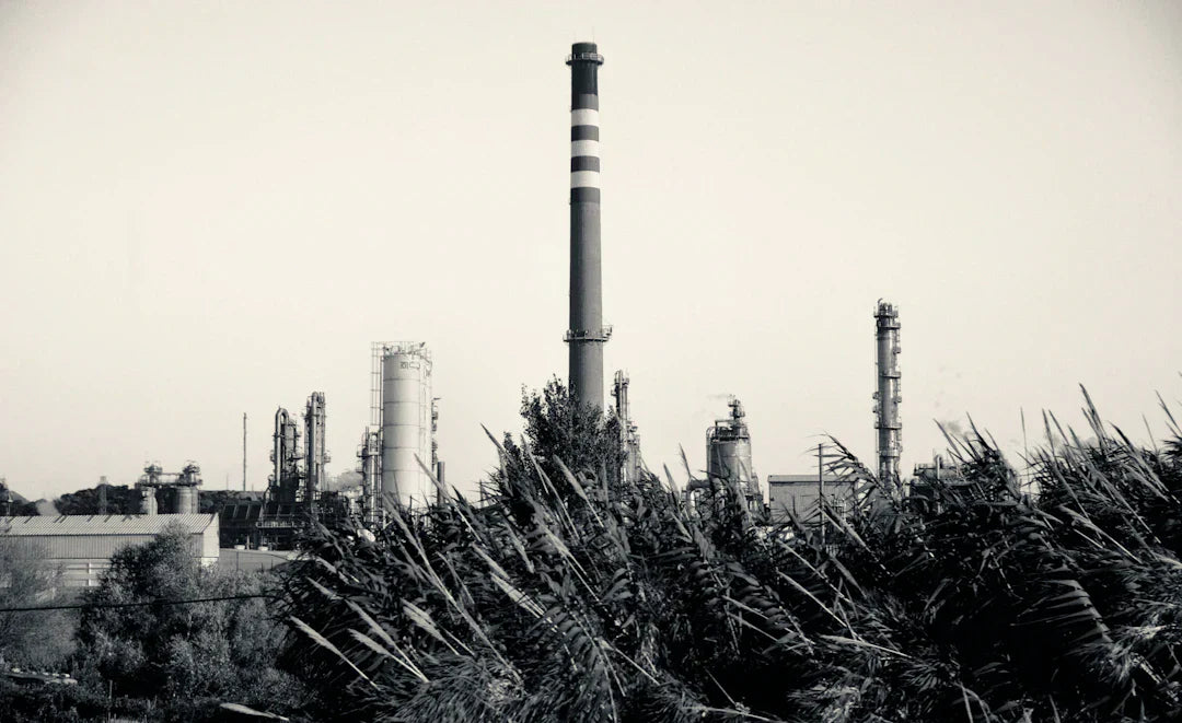 Industrial plant with tall striped smokestack illustrating modern business practices