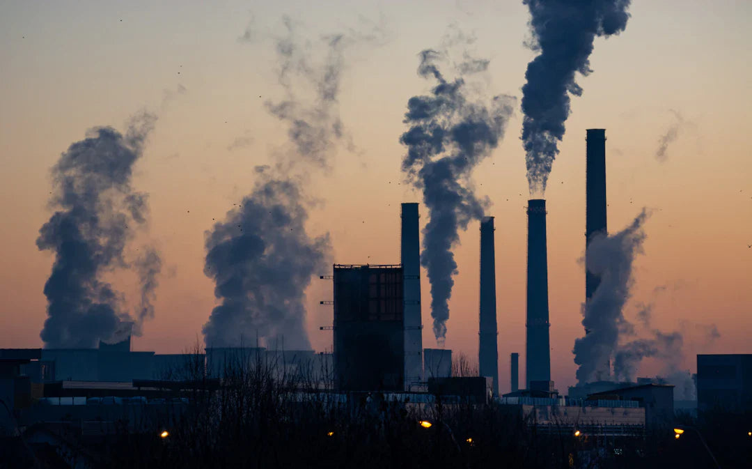 Industrial smokestacks polluting twilight sky, urging sustainable future