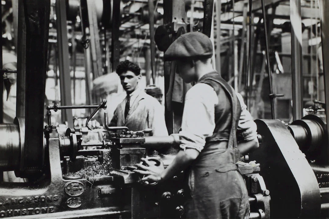 Two men working on industrial machinery during the American Industrial Revolution