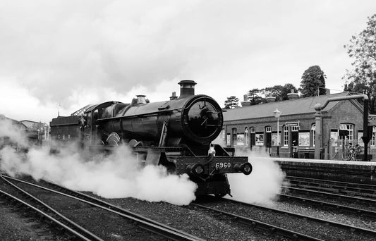 Black steam engine with white smoke symbolizing the industrial revolution in American industry