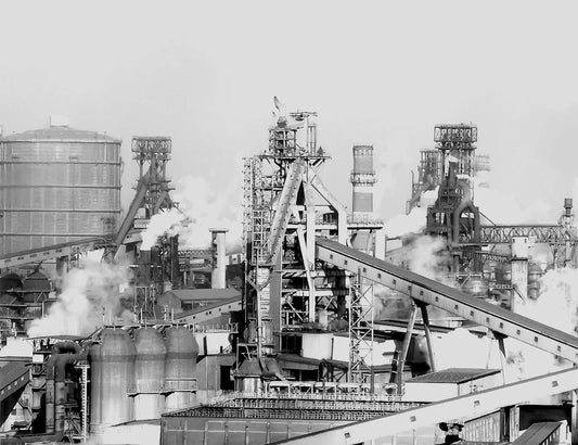 Industrial revolution era factory with blast furnaces, steam, and heavy manufacturing.