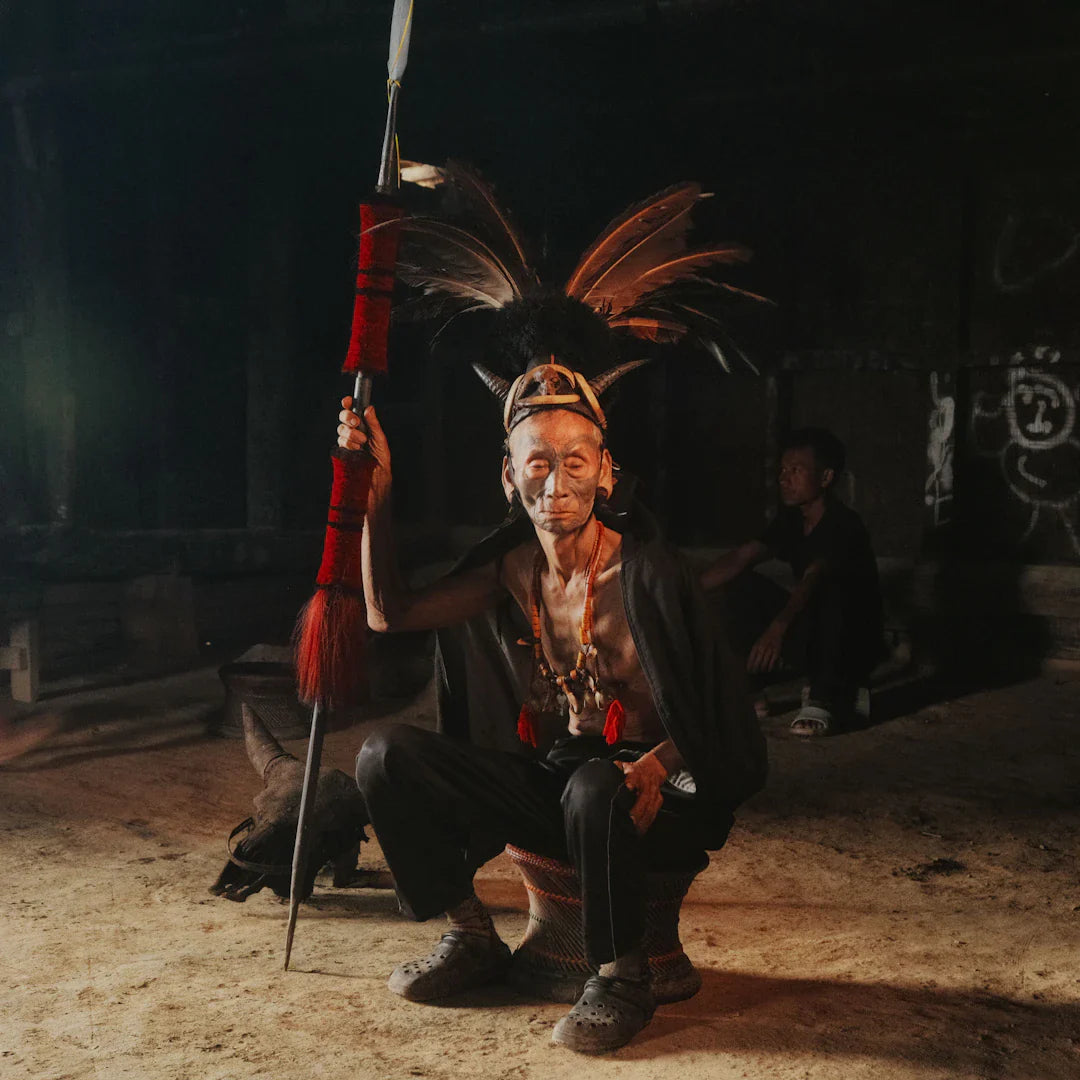 Red feathered staff with black handle in Indigenous Peoples article