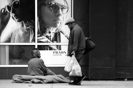 Homeless man on blanket amid income inequality in urban America