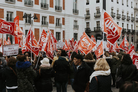 Workers with red and white UGT flags protest for fair wages.