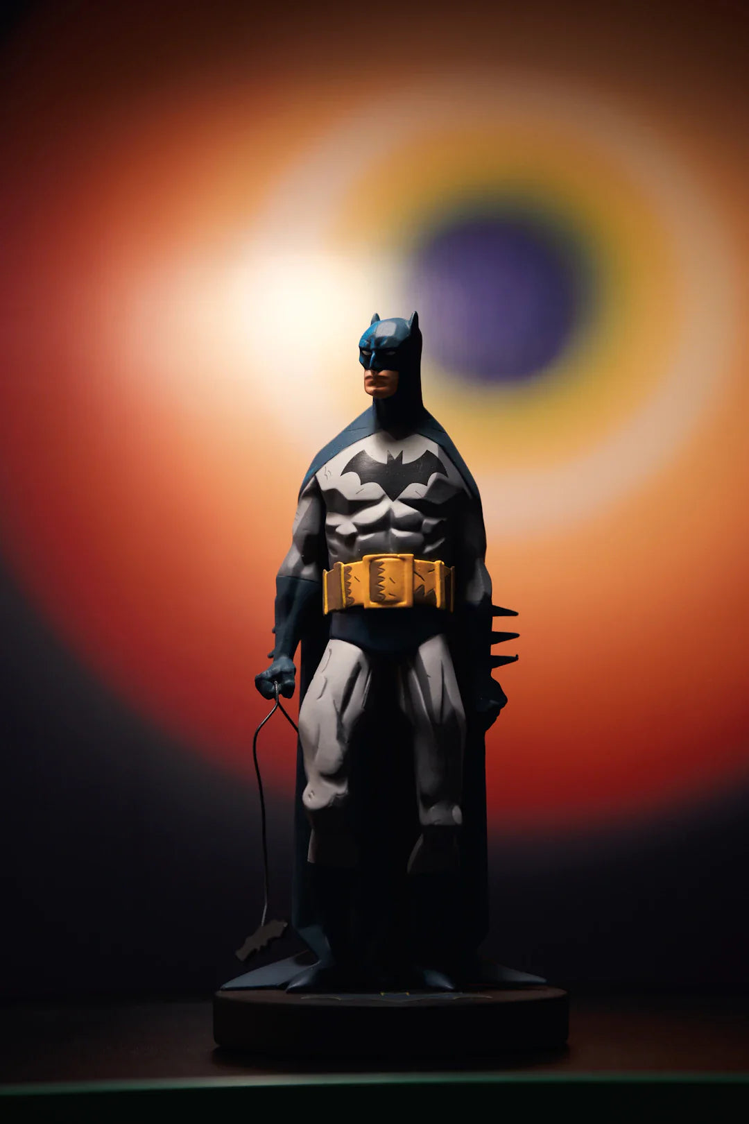Batman statue in black gray suit on comic book cover