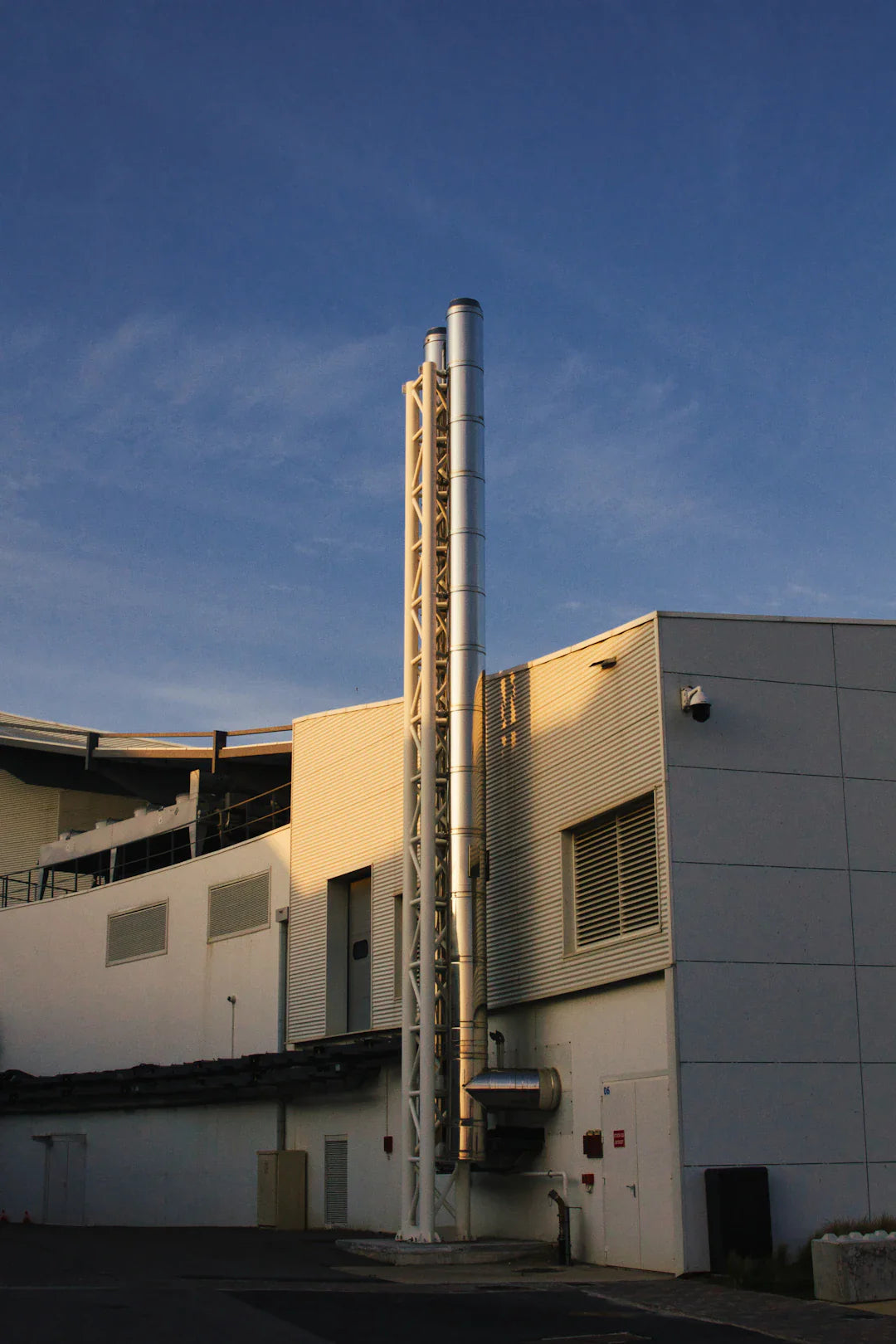 Industrial building with tall metal chimneys in American industries promoting green technology