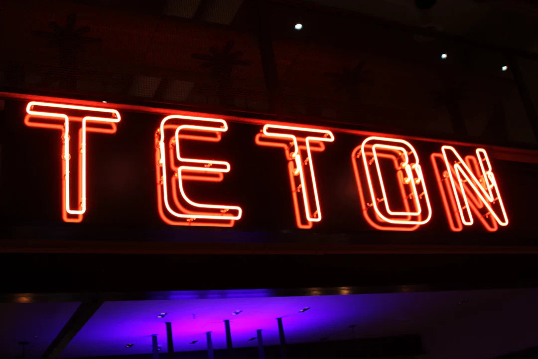Glowing red neon sign spelling TETON representing Wild West culture and cowboy traditions