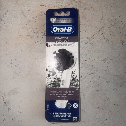 Oral-B Charcoal replacement brush heads package displayed flat on concrete surface, showing blue and white packaging with charcoal brush head image.