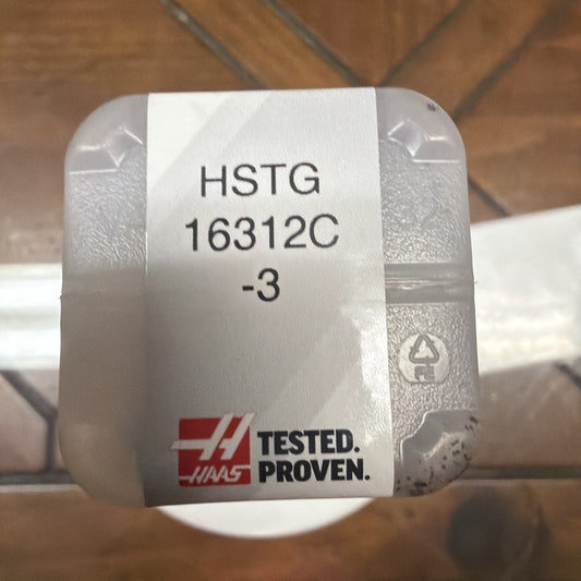Top-down view of HAAS HSTG 16312C-3 tool holder showing white label with text and red "TESTED. PROVEN." logo on metallic gray holder.