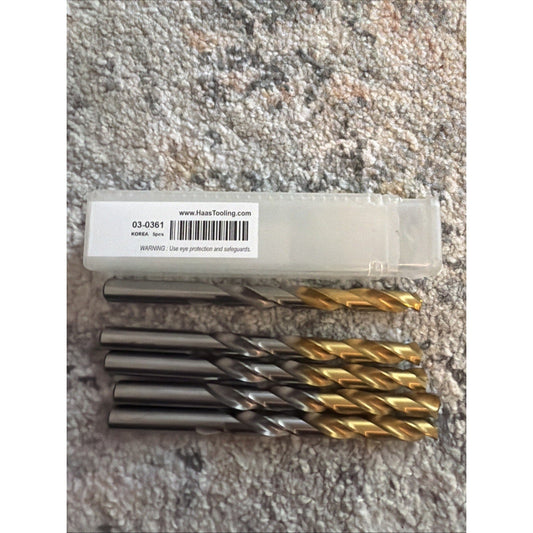 Five TiN-coated gold and gray jobber drill bits displayed next to white packaging label on textured surface.
