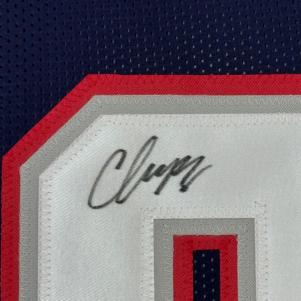 Black ink Christian Gonzalez signature on white patch of framed New England jersey