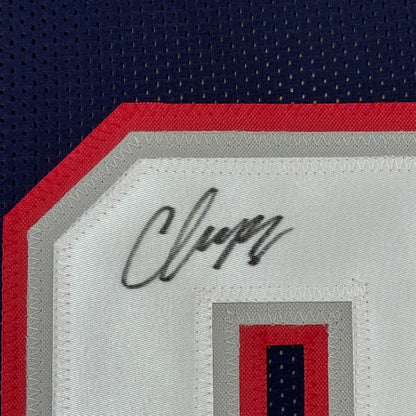 Black ink Christian Gonzalez signature on white patch of framed New England jersey