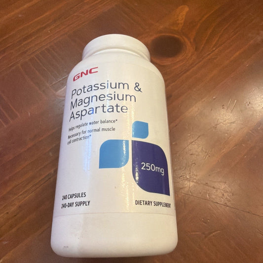 White GNC supplement bottle with blue and purple label containing 240 capsules, displayed on wooden surface.