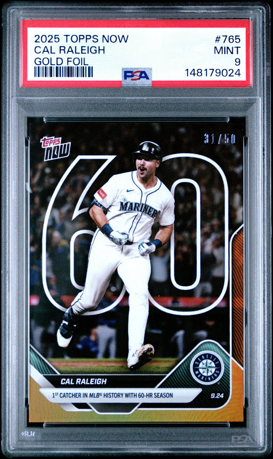 PSA-graded 2025 Topps Now Cal Raleigh gold foil baseball card #765 in clear protective case showing player mid-swing in Mariners uniform.