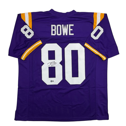 Purple LSU football jersey number 80 with "BOWE" nameplate, displayed flat, showing front view with white numerals and autographed signature.