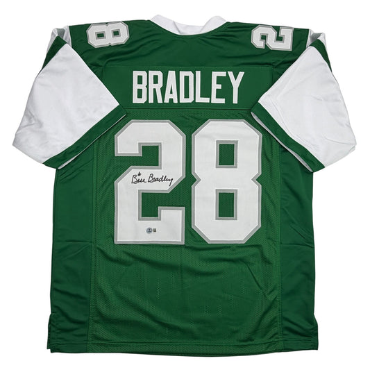 Green and white football jersey with "BRADLEY" nameplate and number 28, displayed flat against white background, showing front view with autographed signature visible on chest.