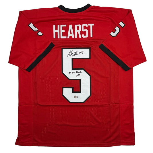 Red college football jersey with "HEARST" and number 5 printed on back, featuring handwritten signatures on the white number.