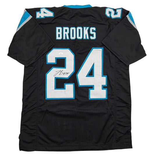 Back view of black Carolina Panthers football jersey number 24 with "BROOKS" nameplate and blue trim, autographed.