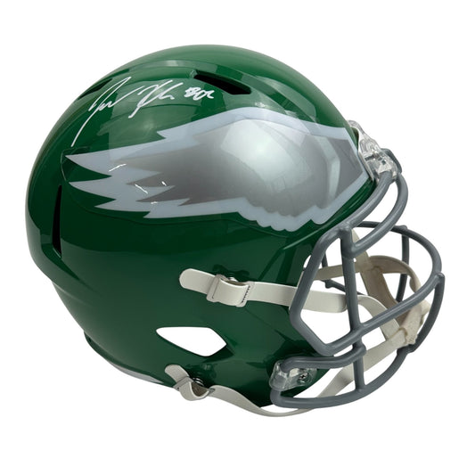 Green Philadelphia Eagles full-size replica helmet with white eagle logo and autographed signature on side, three-quarter view.