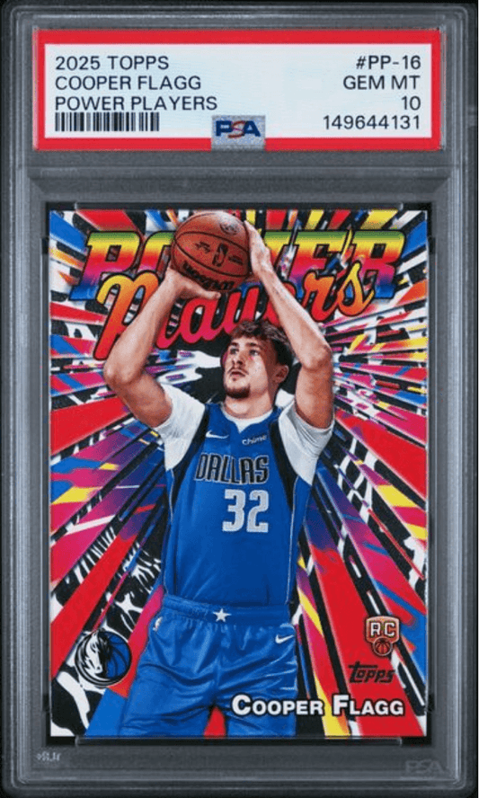 PSA-graded trading card in clear case showing Cooper Flagg in Dallas Mavericks blue jersey shooting basketball against colorful starburst background.