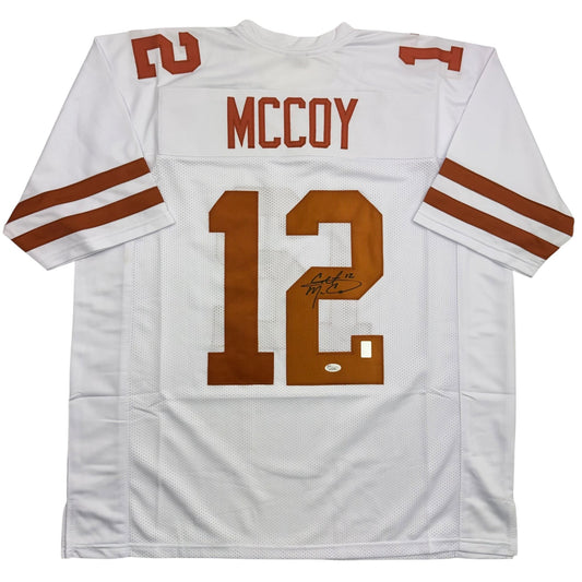 White Texas Longhorns football jersey number 12 with "McCoy" nameplate and autograph visible on front, displayed flat against white background.