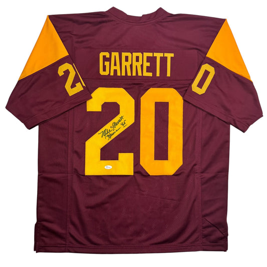 Maroon and gold USC football jersey number 20 signed by Mike Garrett, displayed flat against white background.