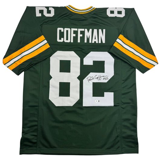Green Bay Packers green jersey number 82 with "COFFMAN" nameplate, displayed flat showing back and sleeve stripes with autograph.