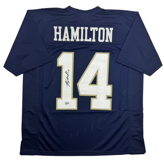 Back view of navy blue Notre Dame football jersey number 14 with "HAMILTON" nameplate and autographed signature on white numerals with gold trim.