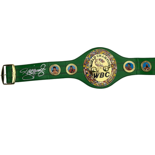 Green WBC championship belt displayed horizontally showing signed left side, center gold plate with motorcycle logo, and decorative portrait medallions.