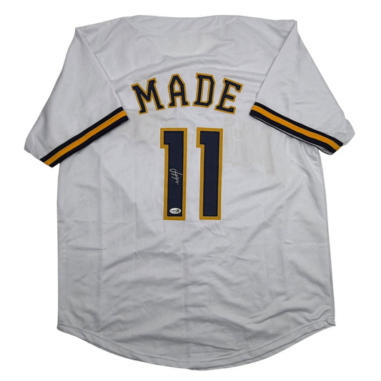 White baseball jersey with "MADE" printed above number "11" in gold and navy, displayed flat on white background showing front view.