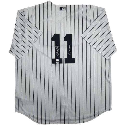 White pinstriped Yankees jersey with black number 11 and two signatures on the chest, displayed flat against white background.