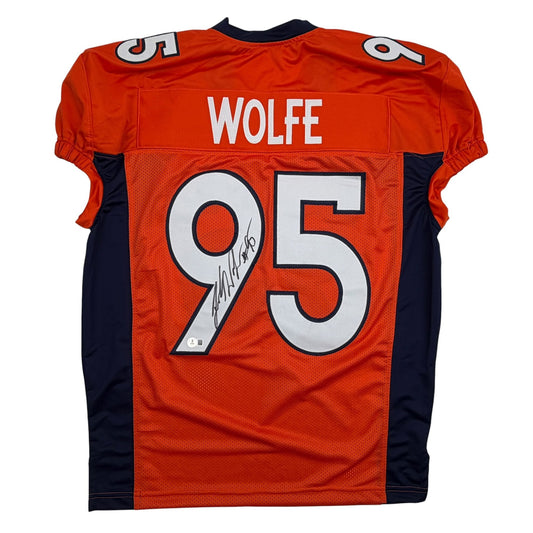 Back view of signed orange Denver Broncos jersey number 95 with "WOLFE" nameplate and autograph on number.