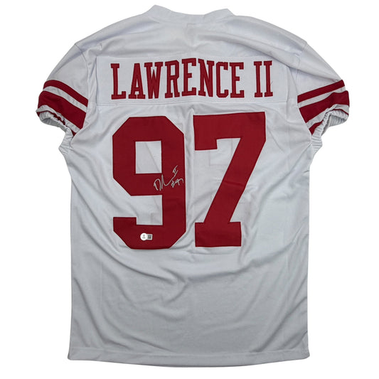 Back view of white football jersey with red number 97 and "LAWRENCE II" nameplate, featuring red sleeve stripes and autographed signature.
