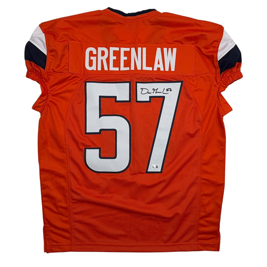 Back view of signed orange Denver Broncos football jersey number 57 with Greenlaw nameplate and handwritten signature.