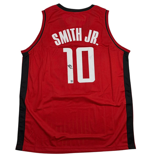 Back view of red basketball jersey with black side panels, white "SMITH JR." and number "10" text, and signature on number.
