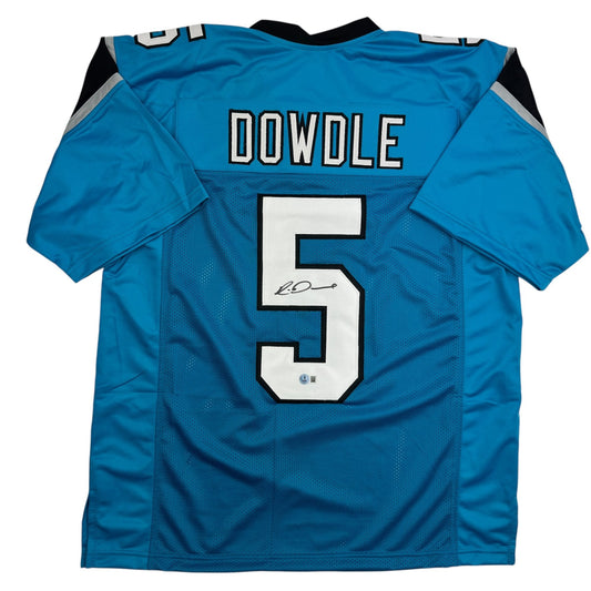Back view of signed blue Carolina Panthers jersey number 5 with "DOWDLE" name plate and autograph on white numeral.