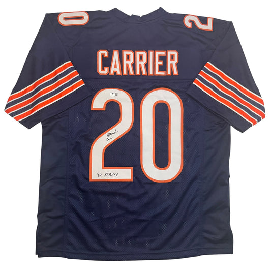 Navy blue Chicago Bears football jersey number 20 with "CARRIER" name and orange striping, displaying handwritten autograph and "90 DROY" inscription on front.