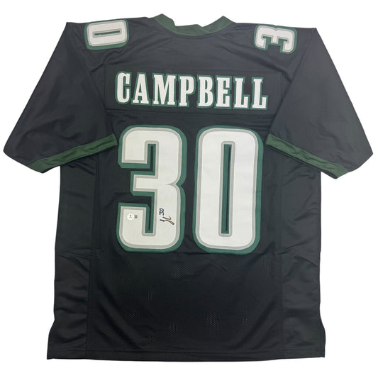 Back view of black football jersey with green and white "CAMPBELL 30" lettering and visible autograph on the number.