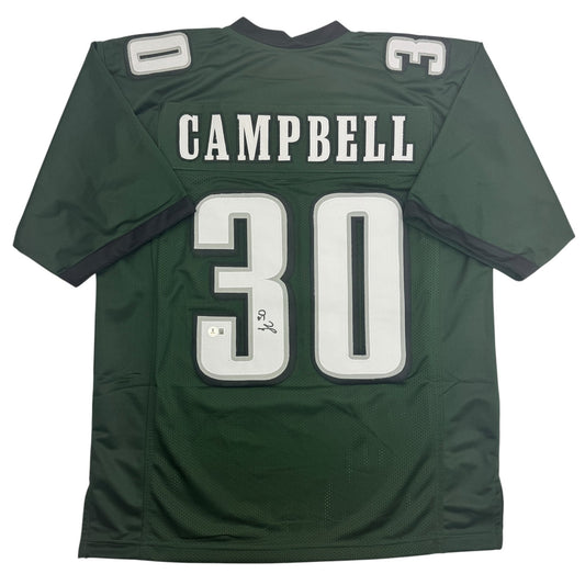 Back view of green football jersey with white "CAMPBELL" nameplate and "30" number, displaying autograph on the chest area.