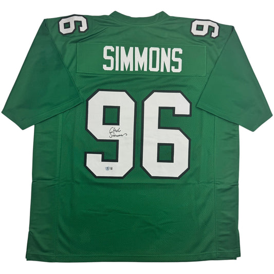 Green football jersey with white "96" and "SIMMONS" nameplate, displayed flat against white background, showing front view with autograph visible on number.