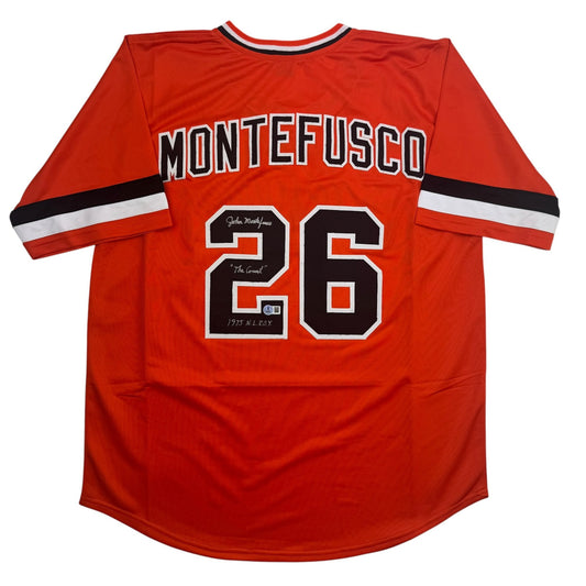 Back view of red Montefusco baseball jersey number 26 with black and white striping and handwritten signatures on the number.